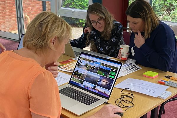 Image of  group of people sitting around looking at computers