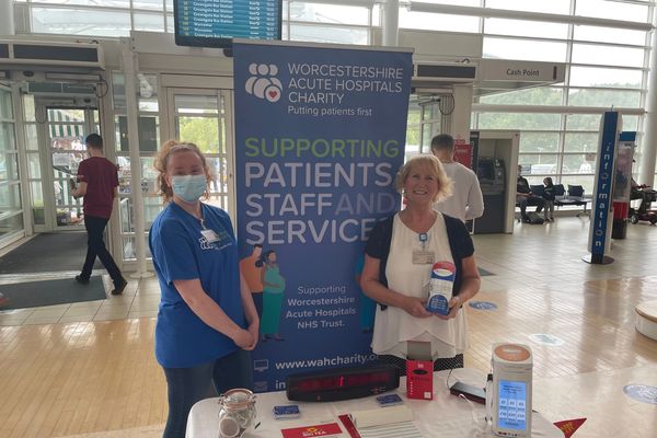 Image of two people standing in front of charity banner