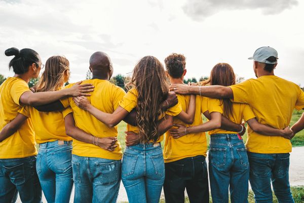 Group of people with their arms round each other and backs to the camera