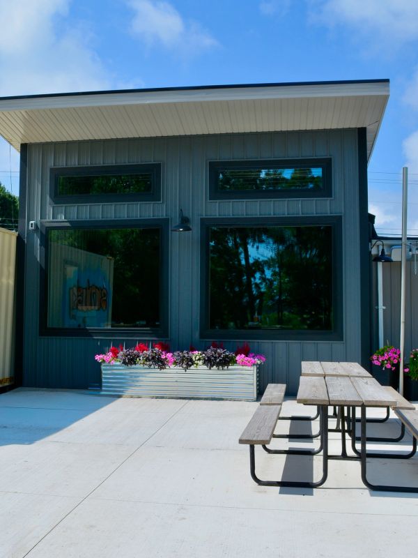 Modern outdoor seating area with picnic tables and planter boxes.