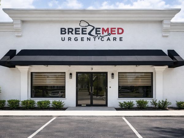 Front view of BreezeMed Urgent Care with black awning and white building exterior.