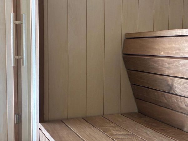 Finishing touches of the custom sauna build showing interior finish to the seating and wall claddings
