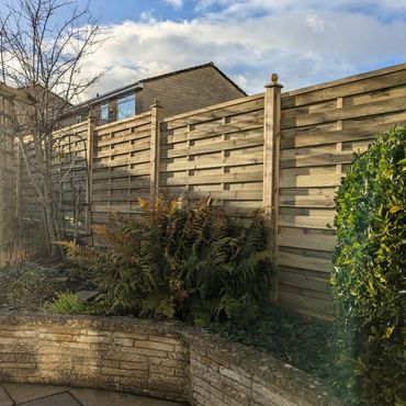 Panel fence on a slope, with finial detail.