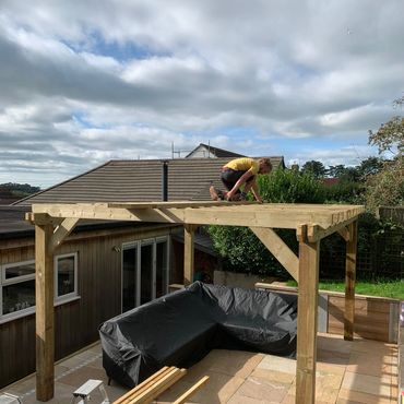 Matt on top of a pergola, attaching stringers to the top.