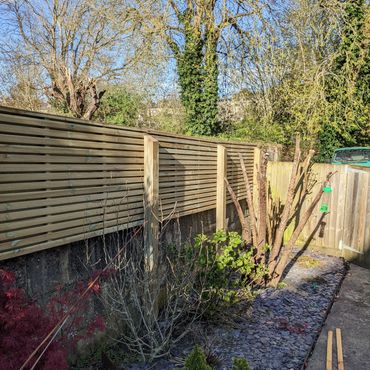 Modern slatted screen fence installation.