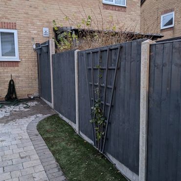 Dark grey panel fence with concrete posts and gravel boards.