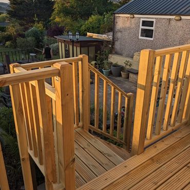 Wooden balustrade and steps down to garden area.