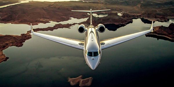 Gulfstream business jet flying over a lake