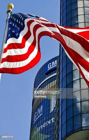 American flag in the foreground of the GM Headquarters, downtown Detroit, Michigan.
