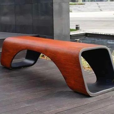 Modern wooden bench with a sleek, curved design outdoors. bancas de acero inoxidable
papeleras
paradas