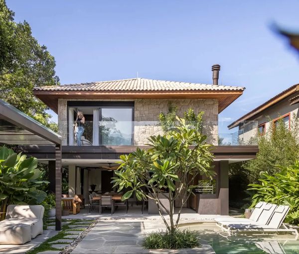 Modern two-story house with a pool and lush greenery in the backyard.
