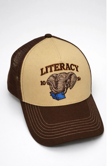 Brown and beige cap with an embroidered elephant reading a blue book and the word 'LITERACY'.