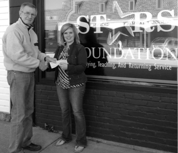 Rebecca Peterson receiving a scholarship check from Richard Sneiderman.