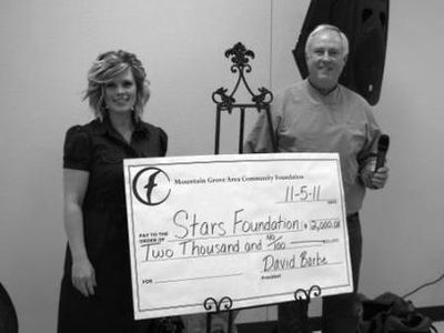 Rebecca Peterson receiving a check from Roger Lindsey.