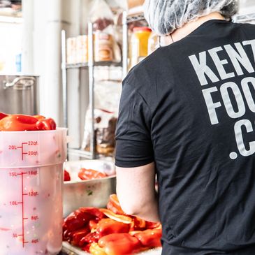 Person preparing red bell peppers in a kitchen.