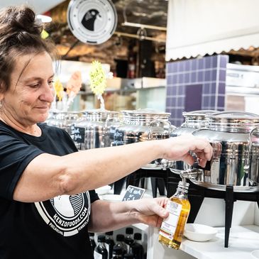 Woman filling a bottle from a dispenser in a store.