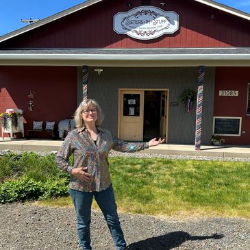 Woman standing in front of a shop named Sisters-N-Stuff.