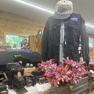 Display of vintage cameras and patriotic ribbons with a mannequin wearing a NASA jacket and cap.
