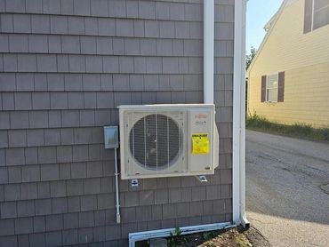 Fujitsu outdoor heat pump unit installed on exterior of Maine home by Bangor HVAC
