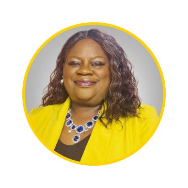 Smiling woman in a bright yellow jacket with a blue necklace.