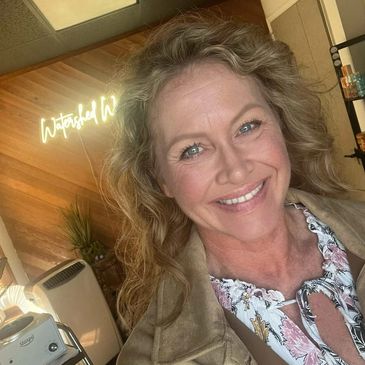 Smiling woman with curly hair indoors.