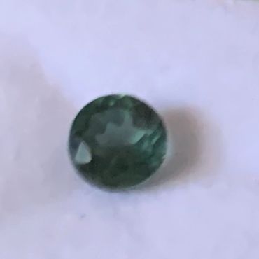 This one carat round cut emerald is a lovely shade of deep green.