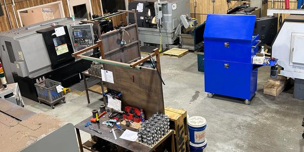 Industrial workshop with machinery, tools, and a blue tool chest.