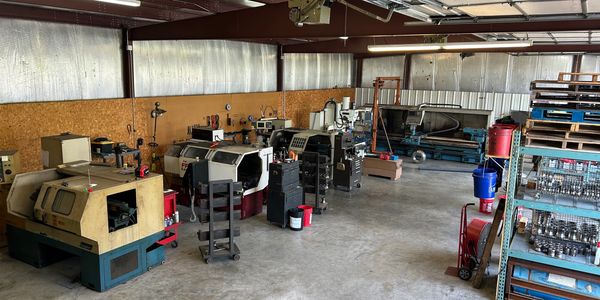 A spacious industrial workshop with various machines and tools neatly arranged.