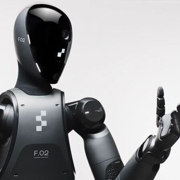 A sleek black humanoid robot with a glossy face and articulated arm.