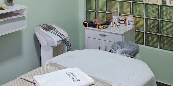 Sala de tratamento com maca e equipamentos médicos.