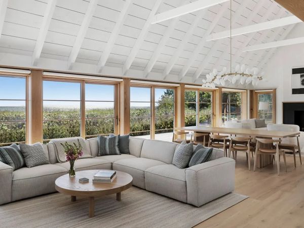Bright modern living room with large windows and a cozy sectional sofa.