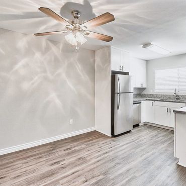 Modern kitchen with stainless steel appliances and wood flooring.