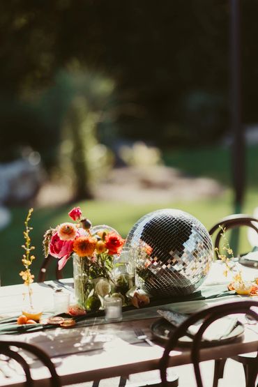Photo of reception table with brightly colored decor and disco ball. Photo: The Wickerts Photography