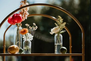 Bud vases of bright flowers and fresh lemon & lime on a glass shelf. Photo: The Wickerts Photography