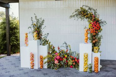 Ceremony Florals display with bright flowers and fresh citrus fruit. Photo: The Wickerts Photography