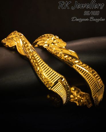 Elegant gold designer bangles with intricate floral and chain details.