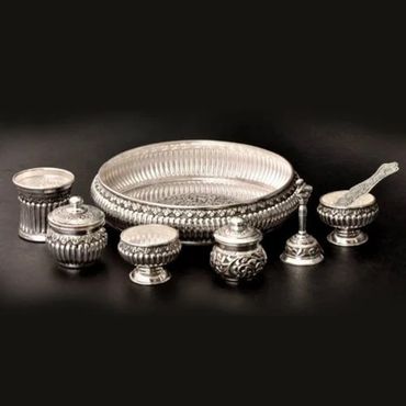 Ornate silverware set including a tray and various containers on a dark background.