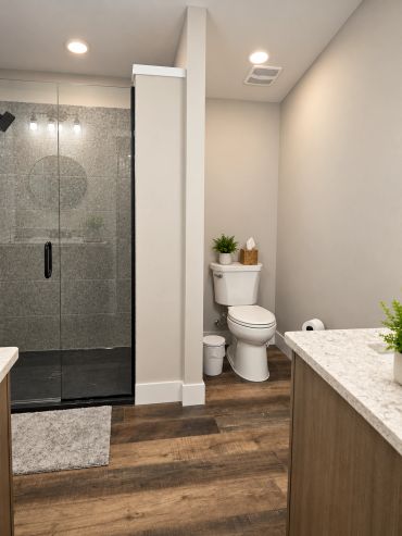 Large walk-in shower with glass doors and modern black fixtures in the Patt’s Place Modern Camping S