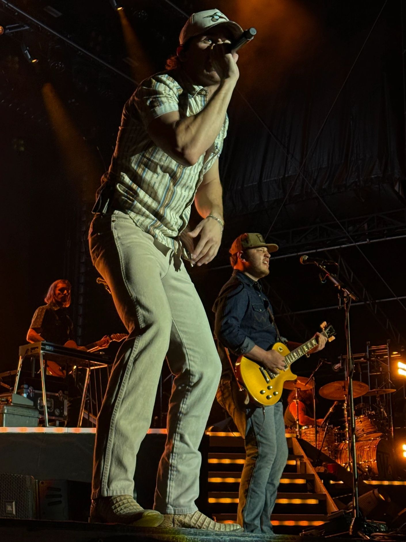 A band performing live on stage with vibrant lighting.