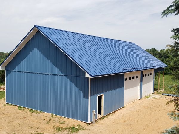 Corrugated metal siding panels and roof in Regal Blue with snow guards on pole shed – Wautoma, WI