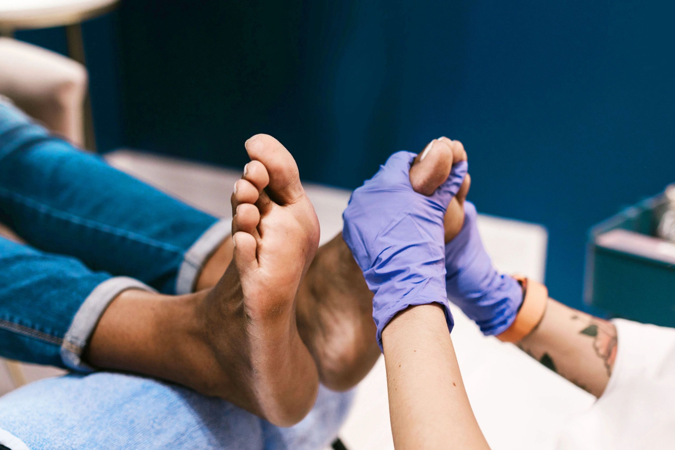 Patient with their feet up as a nurse checks them