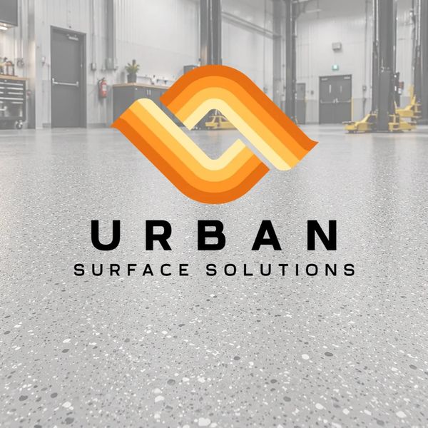 Logo of Urban Surface Solutions over a polished industrial floor in a workshop.