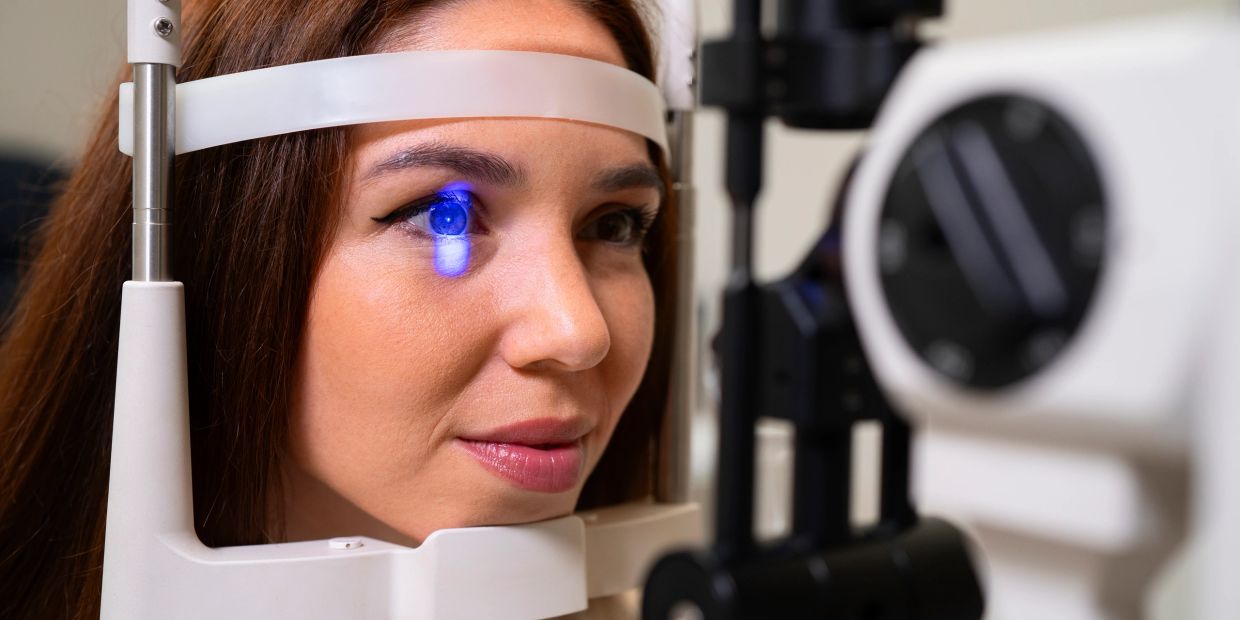 Woman undergoing an eye exam with a blue light scan.