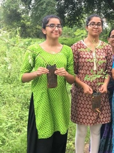 Me and my sister holding the plants for school project in village.