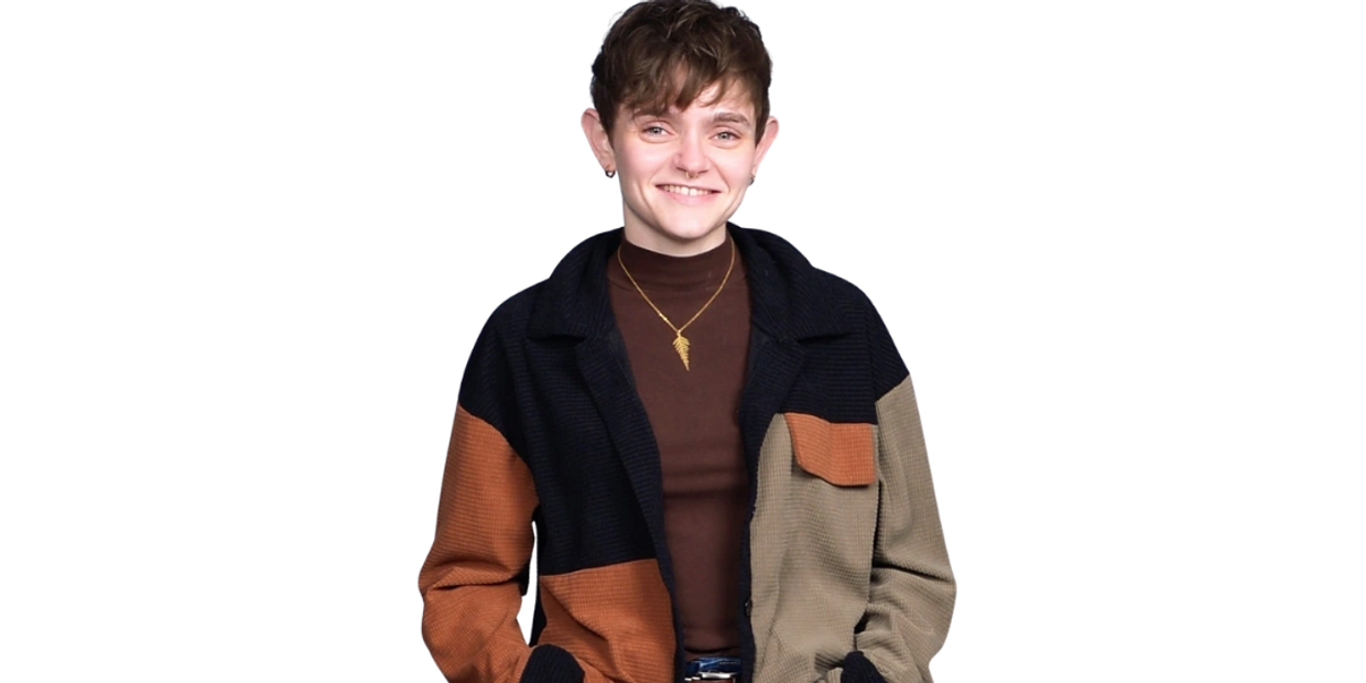 Person smiling with hands in the pockets of a color-blocked jacket.