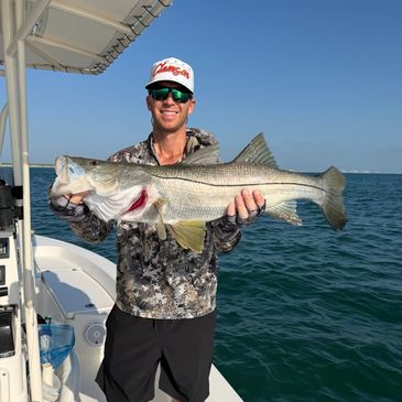 Man holding a large fish on a boat.