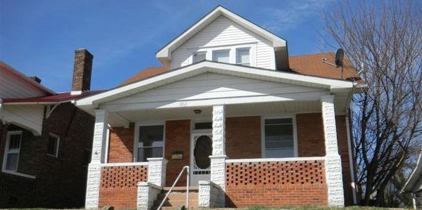 Brick house with a white porch and a small attic window.