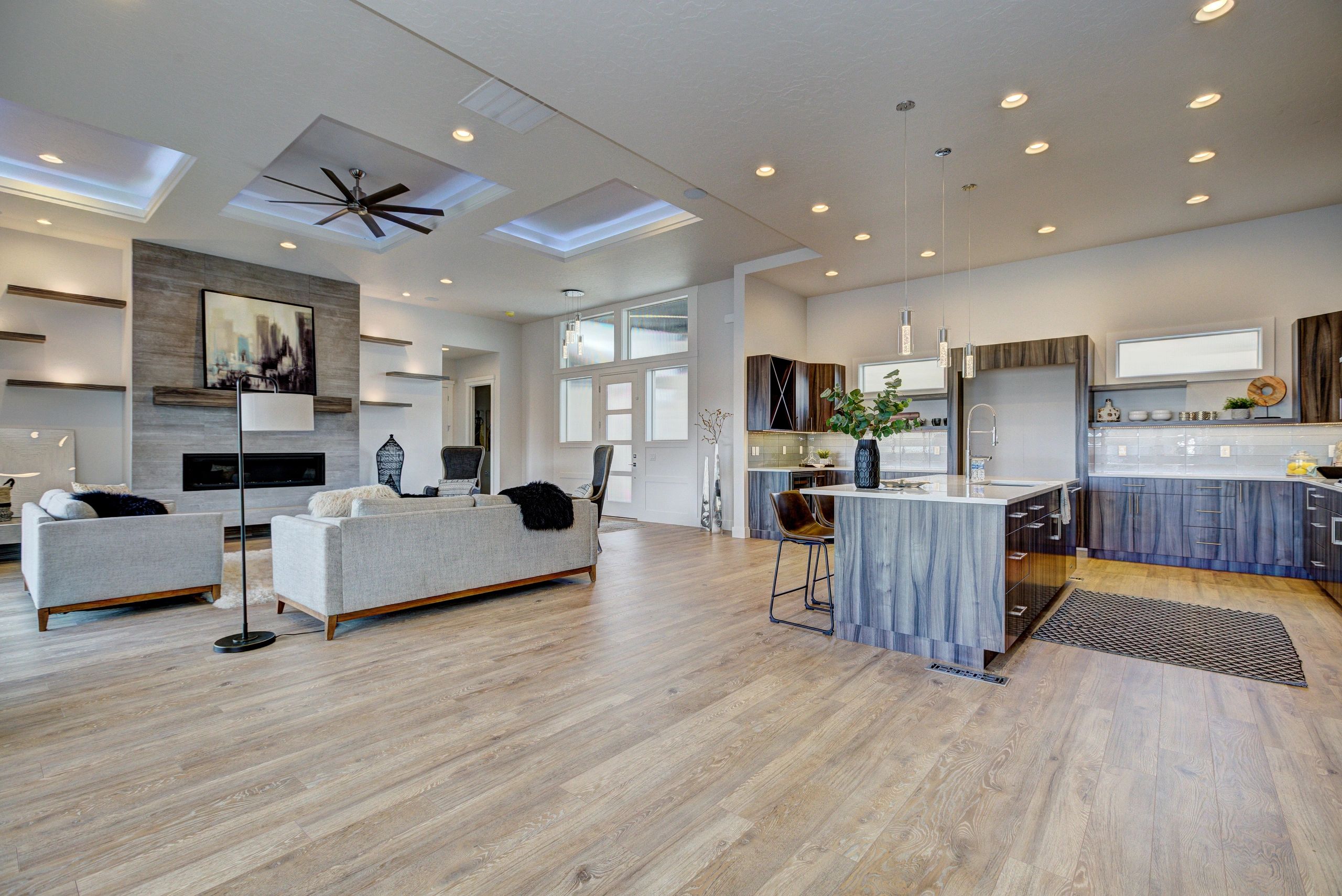 Modern open living room and kitchen with wood flooring.