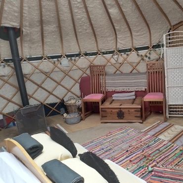 Yurt interior with warm atmosphere, bedding and furnishings for a relaxing countryside stay