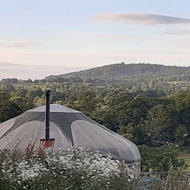 View of Alfred’s Tower from Sunny Hill Campsite with countryside landscape surrounding the yurt